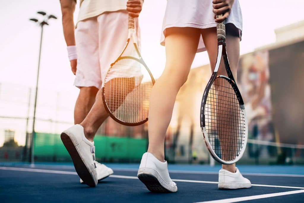 Shot of couple's legs while playing tennis
